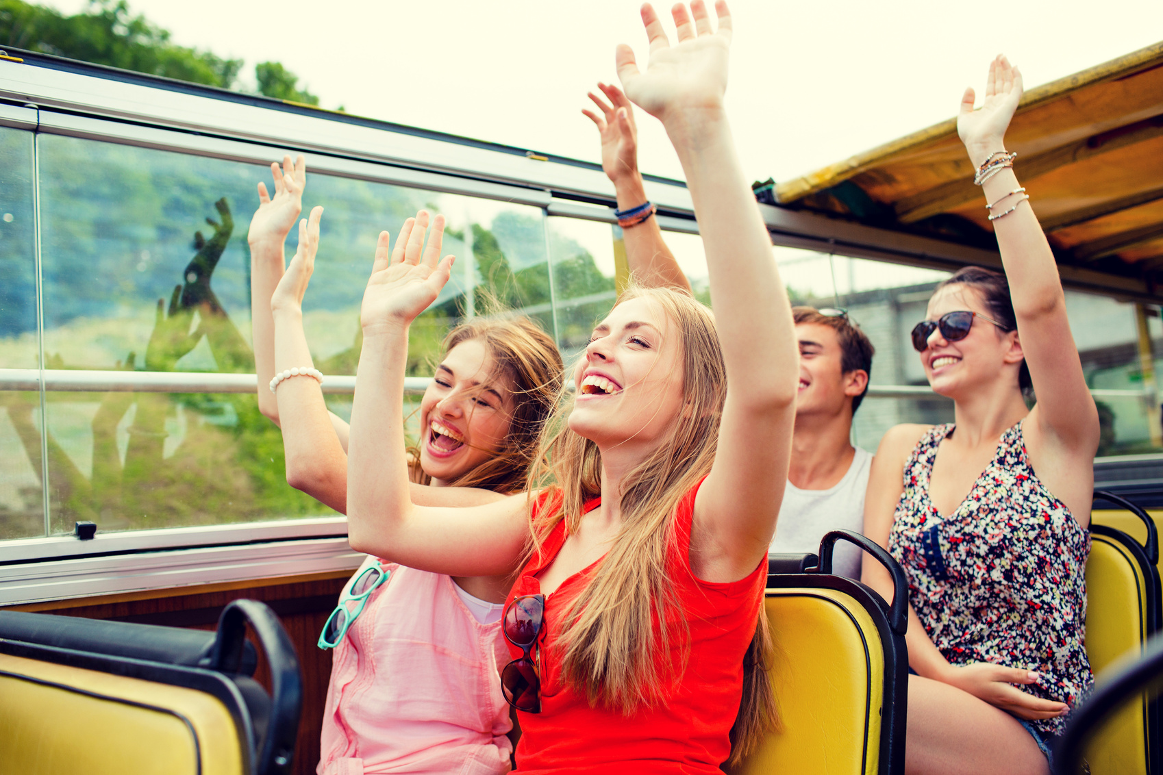 Group of Smiling Friends Traveling by Tour Bus